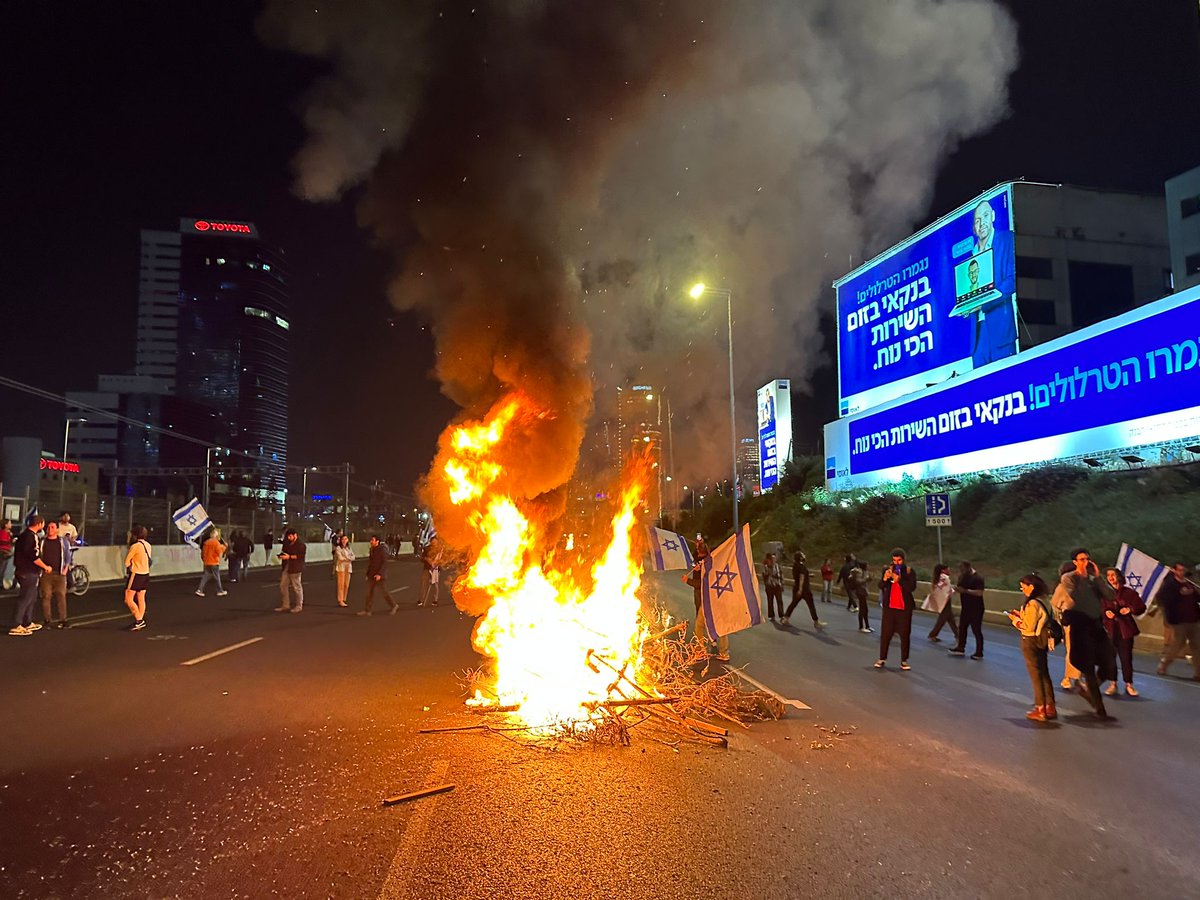 Protesters lit a large bonfire in Ayalon South and chanted The country is on fire.