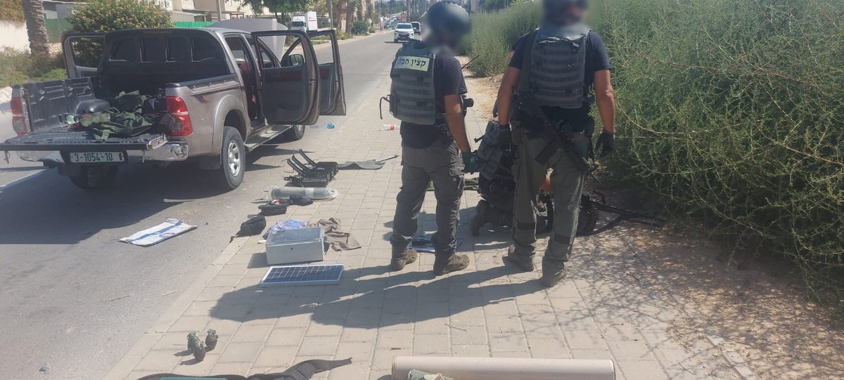 Police sappers handling weapons found on Hamas trucks in southern Israel