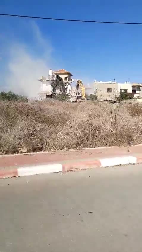 Tratores demolindo uma casa na vila de Tura, a oeste da cidade de Jenin