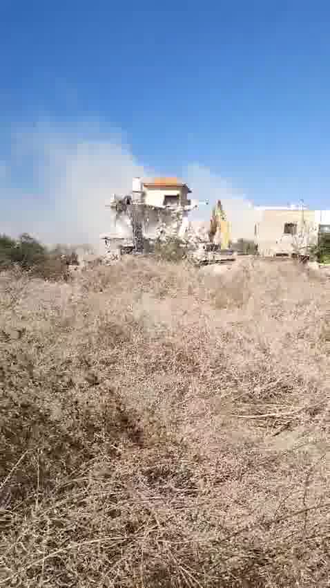 Tratores demolindo uma casa na vila de Tura, a oeste da cidade de Jenin