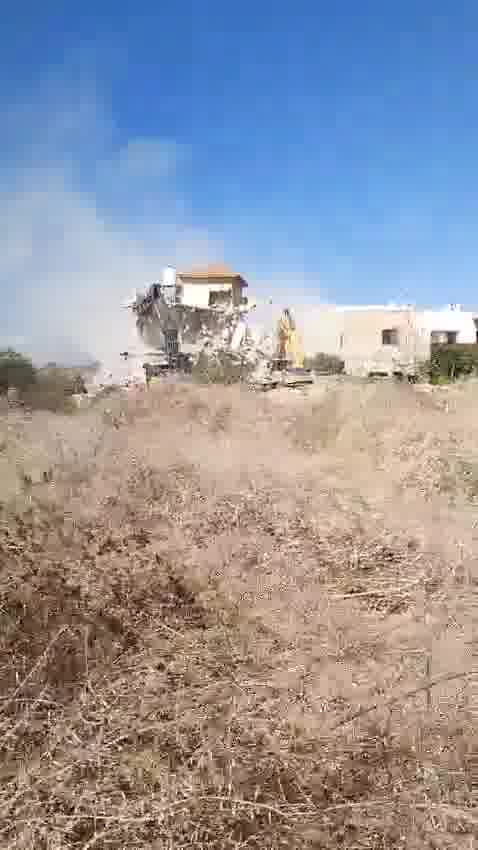 Tratores demolindo uma casa na vila de Tura, a oeste da cidade de Jenin