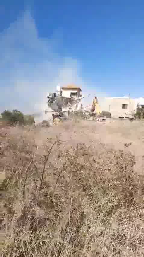 Tratores demolindo uma casa na vila de Tura, a oeste da cidade de Jenin