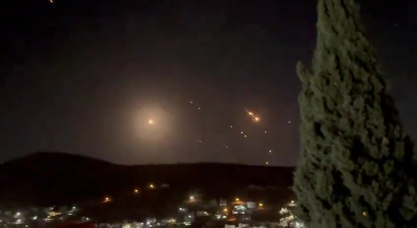 What appears to be ballistic missiles fired from Iran coming down on Israel