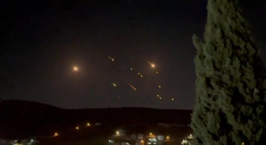 What appears to be ballistic missiles fired from Iran coming down on Israel