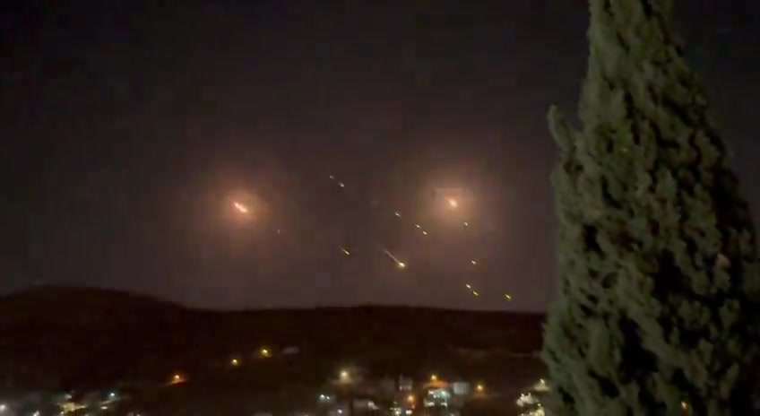 What appears to be ballistic missiles fired from Iran coming down on Israel