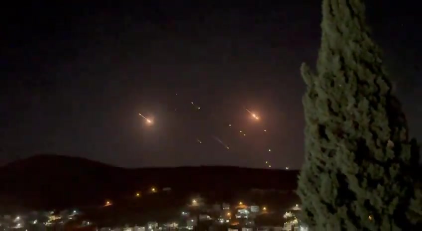 What appears to be ballistic missiles fired from Iran coming down on Israel