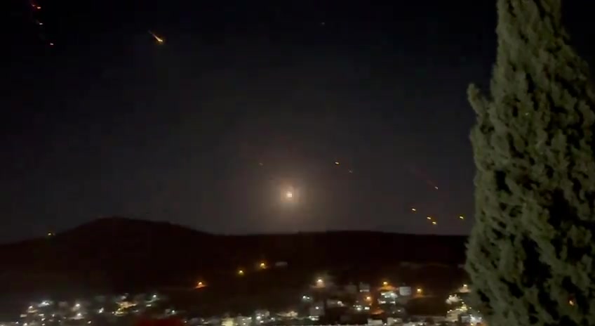 What appears to be ballistic missiles fired from Iran coming down on Israel