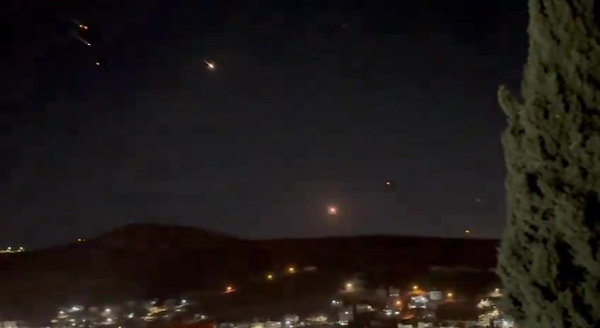 What appears to be ballistic missiles fired from Iran coming down on Israel