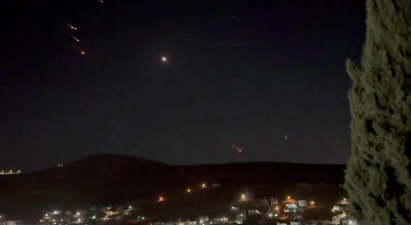 What appears to be ballistic missiles fired from Iran coming down on Israel