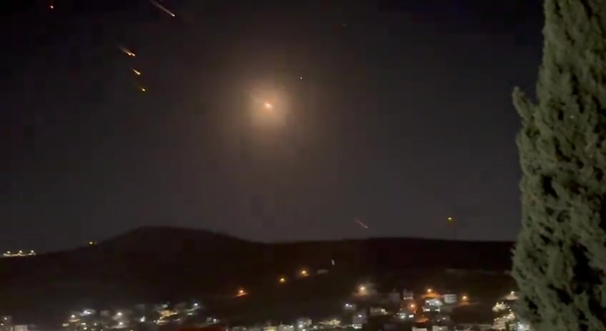 What appears to be ballistic missiles fired from Iran coming down on Israel