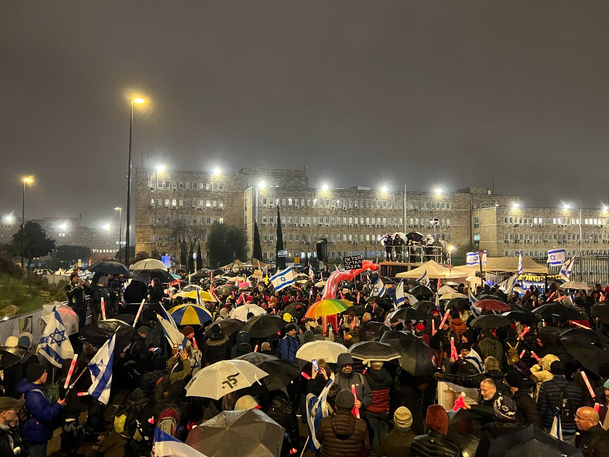 Thousands of Israelis are protesting in the rain in front of the Prime Minister's office as the cabinet convenes to vote on the dismissal of the director of the Shin Bet security agency. The Shin Bet is investigating Netanyahu's aides for alleged payments from Qatar