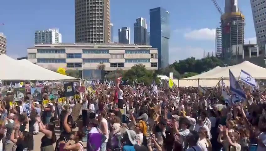 A helicopter carrying freed hostages flies over Hostage Square, greeted by thunderous applause from tens of thousands of Israelis gathered below