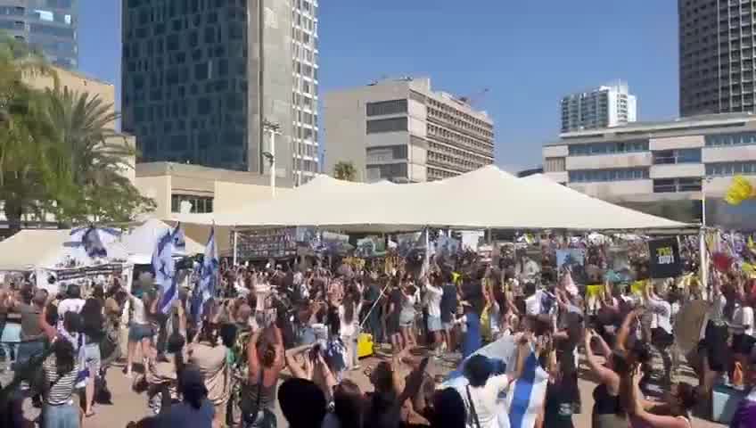 A helicopter carrying freed hostages flies over Hostage Square, greeted by thunderous applause from tens of thousands of Israelis gathered below