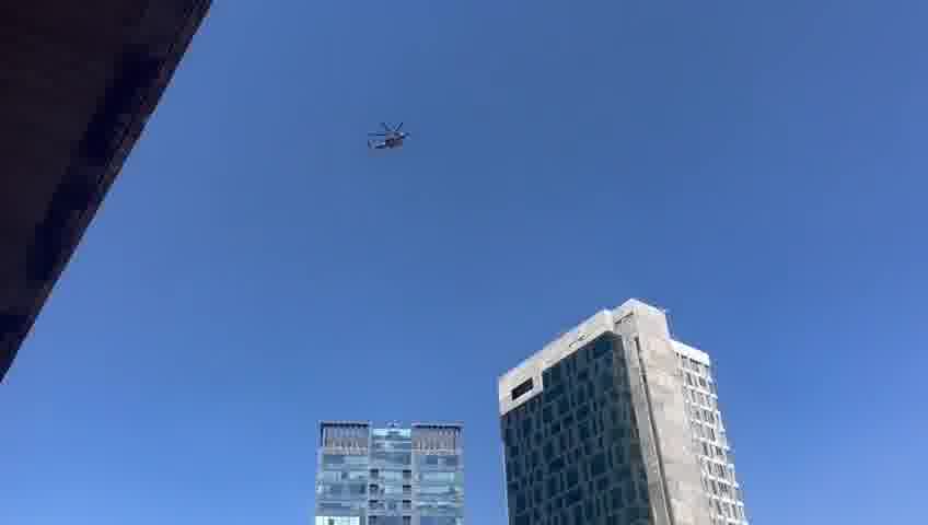 A helicopter carrying freed hostages flies over Hostage Square, greeted by thunderous applause from tens of thousands of Israelis gathered below