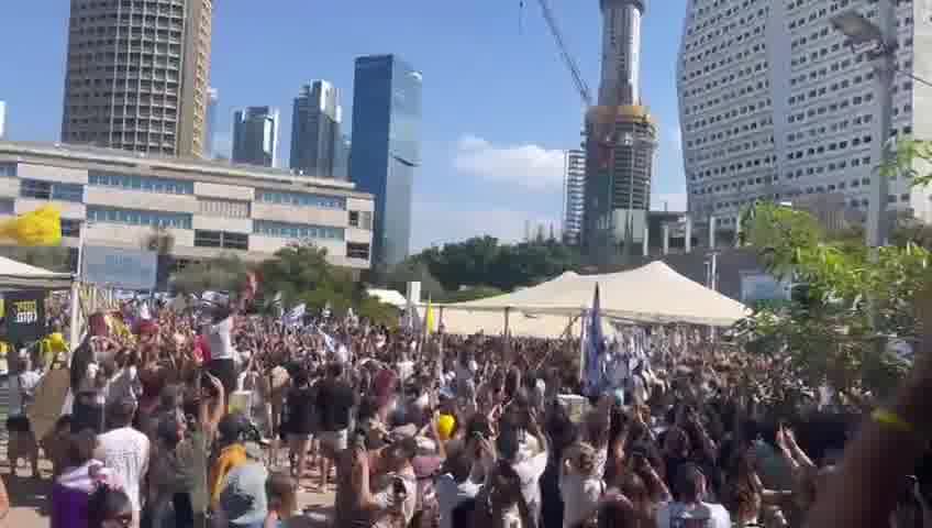 A helicopter carrying freed hostages flies over Hostage Square, greeted by thunderous applause from tens of thousands of Israelis gathered below
