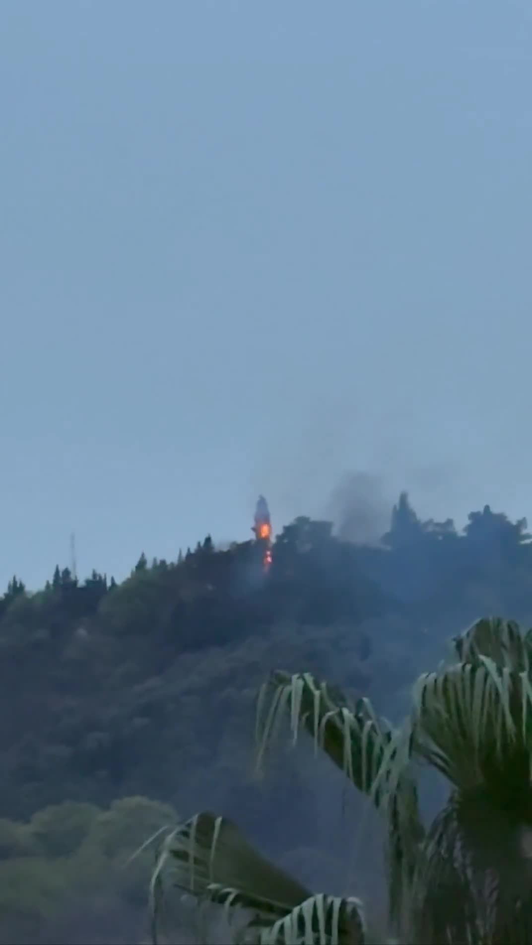 Smoke and fire are seen on top of a hill in the northern city of Behshahr in the early hours of Friday after a strike targeting a radar site