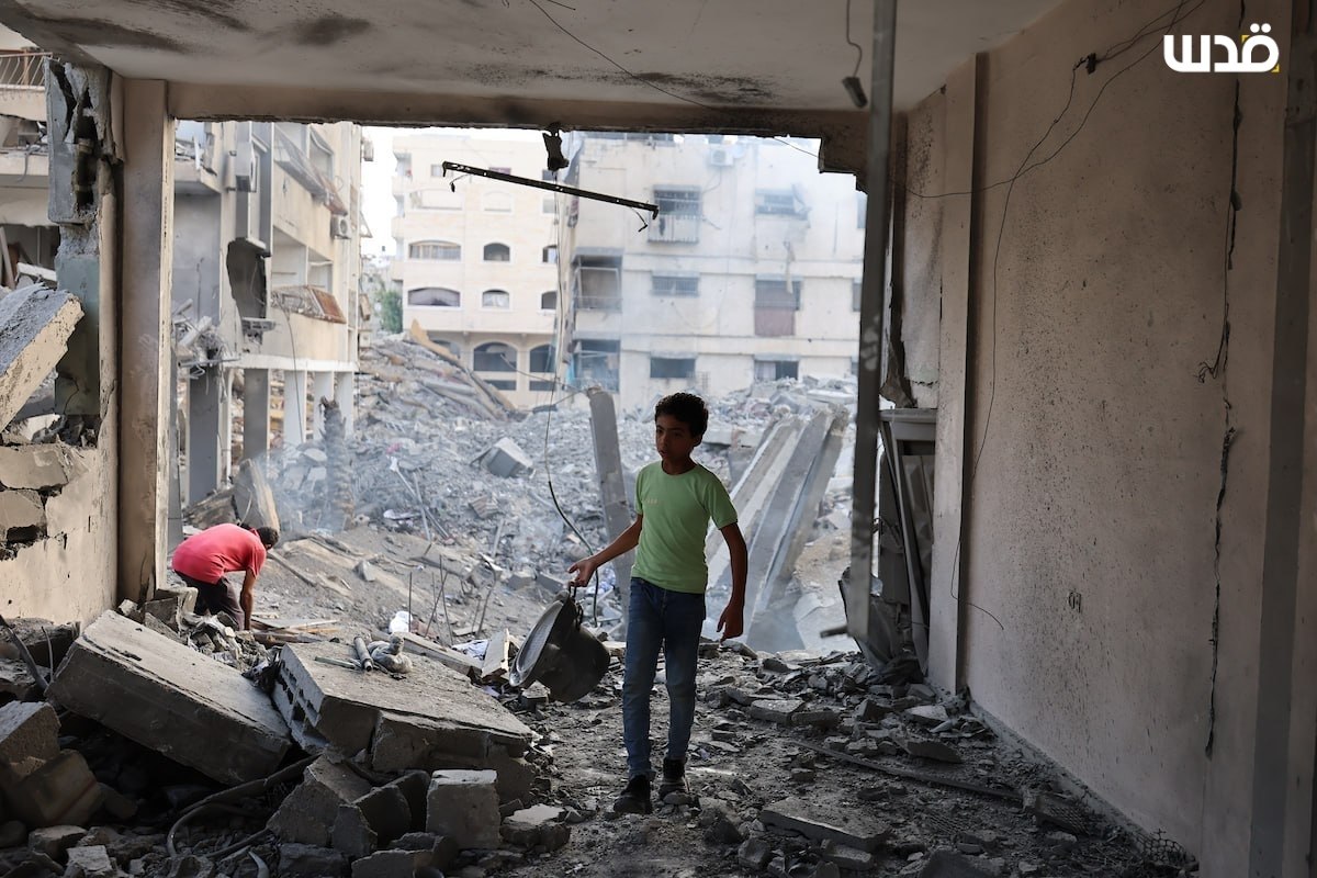Palestinians inspect the damage to a building following an Israeli airstrike last night that targeted Al-Jalaa Street in the center of Gaza City.